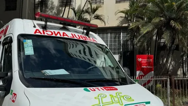 Equipe da Life Remocenter uniformizada ao lado de ambulância UTI móvel durante atendimento noturno